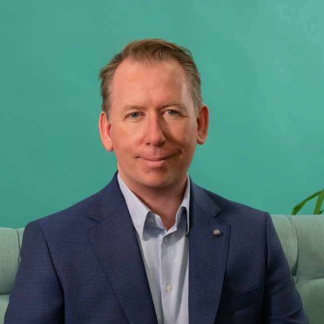 John Margerison in front of blue background